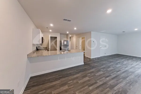 a kitchen with stainless steel appliances granite countertop a refrigerator a sink a stove and oven