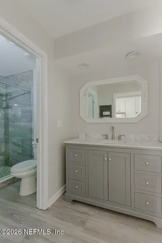 a bathroom with a sink a toilet and a mirror