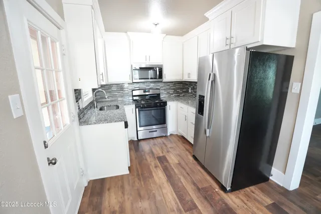 a kitchen with stainless steel appliances a refrigerator and wooden floor