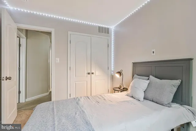 a bedroom with a bed table and a window