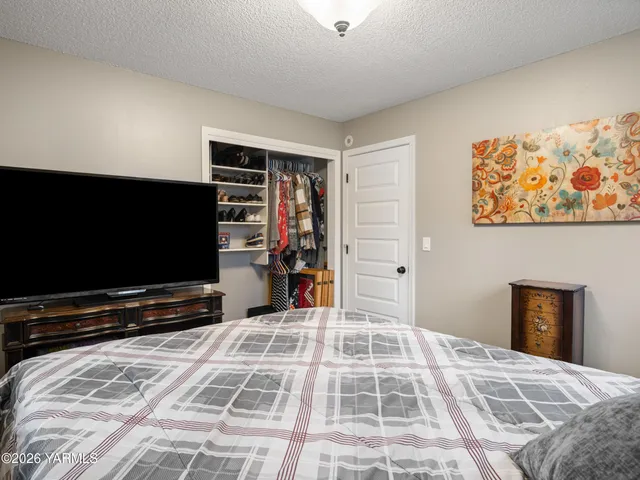 a bedroom with a bed and a flat screen tv