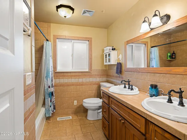 a bathroom with a sink double vanity and a toilet