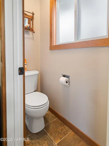 a bathroom with a toilet and a mirror