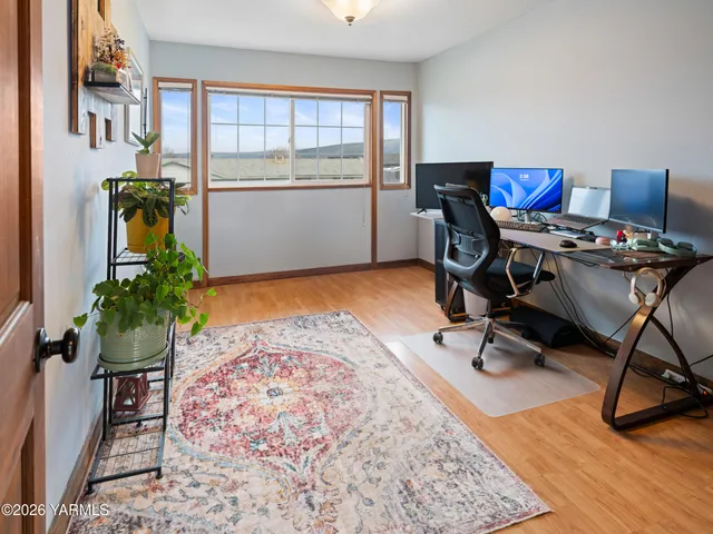 a view of a workspace with furniture and a window