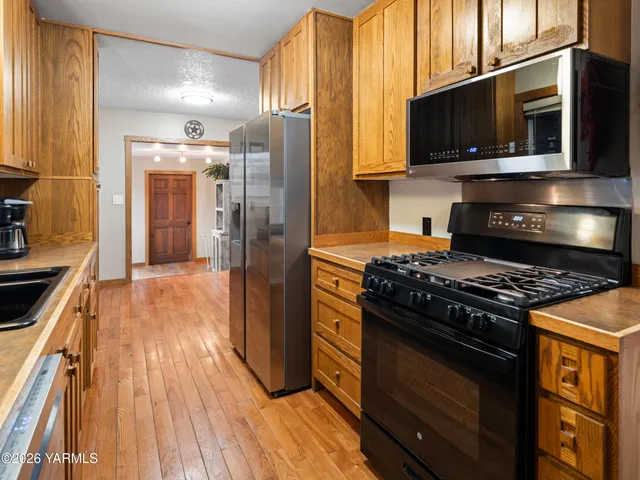 a kitchen with granite countertop wooden floors and stainless steel appliances
