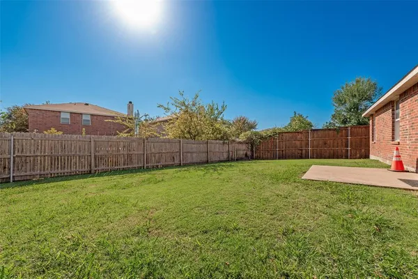 a view of a backyard with wooden fence
