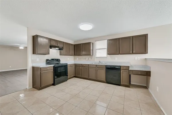 a large kitchen with a stove top oven and cabinets