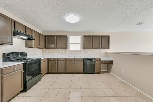 a kitchen with a sink a stove top oven and cabinets