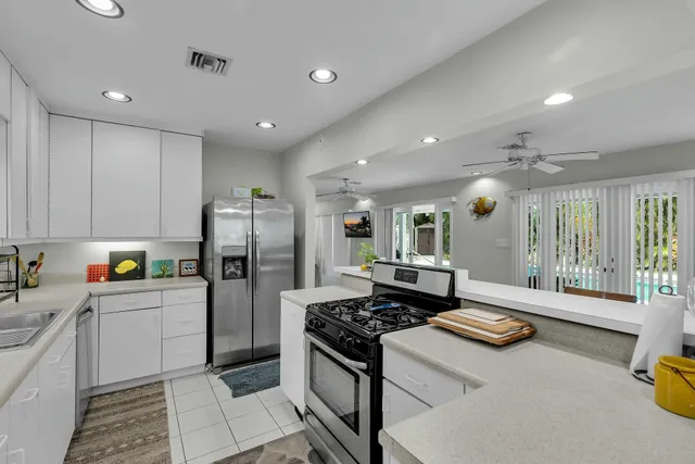 a kitchen with stainless steel appliances granite countertop a refrigerator and a stove top oven