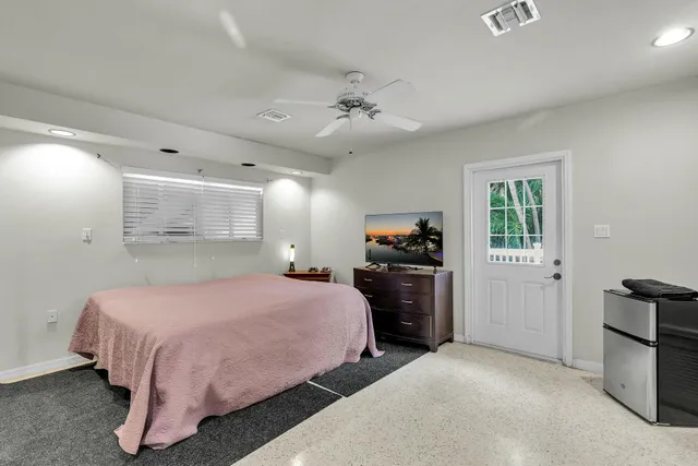 a bedroom with a bed and dresser with mirror