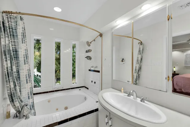 a bathroom with a tub sink and mirror