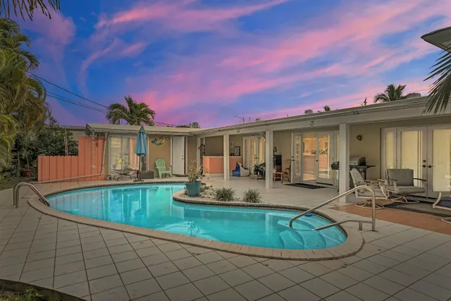 a view of a house with swimming pool and sitting area
