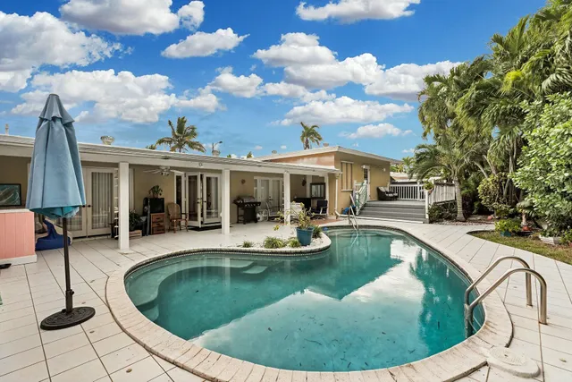 a view of a house with swimming pool and sitting area