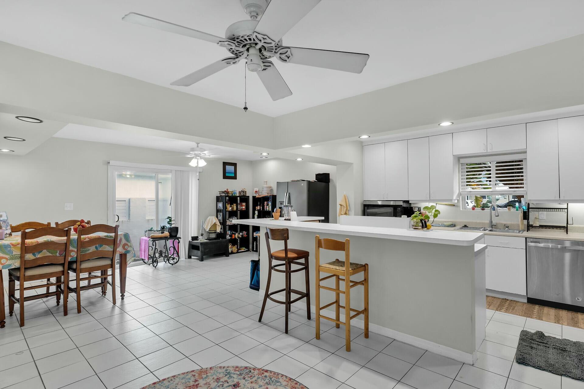 1106 17th Street Key West, FL 33040 - Photo 9 of 33 a kitchen with stainless steel appliances a table chairs refrigerator and cabinets