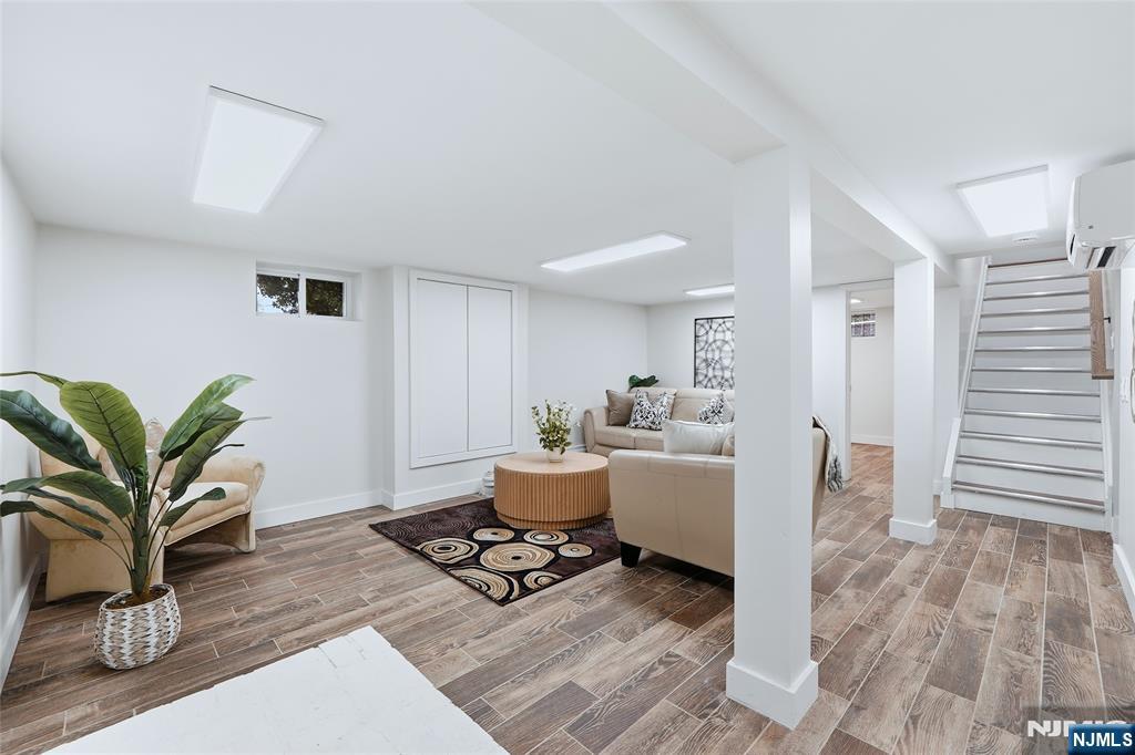 20 Dojean Court Bergenfield, NJ 07621 - Photo 22 of 30 a living room with furniture a wooden floor and a potted plant