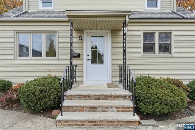 a front view of a house with potted plants