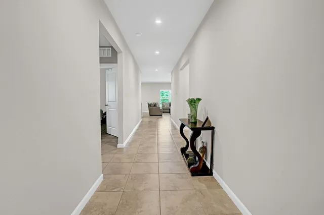 a hallway with table and a potted plants
