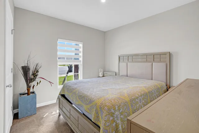 a bedroom with a bed and a flat tv screen on a dresser