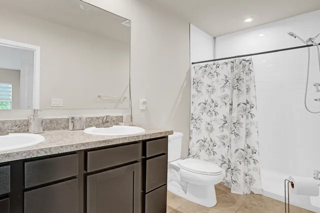 a bathroom with a sink a toilet and shower