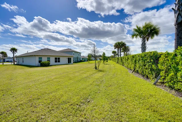 a front view of house with yard and ocean