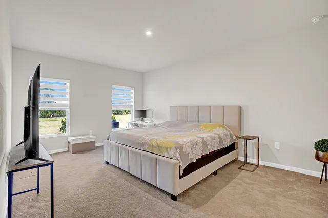 a spacious bedroom with a bed and window