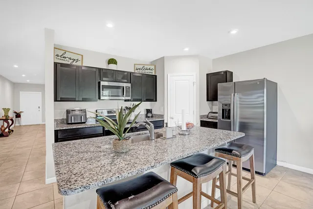 a kitchen with stainless steel appliances granite countertop a refrigerator and a stove