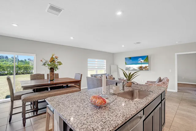 a living room with granite countertop furniture a table and kitchen view