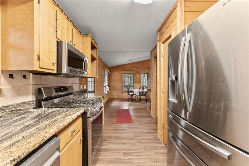279 Cindy Cove Road Blairsville, GA 30512 - Photo 6 of 46 a kitchen with stainless steel appliances granite countertop a refrigerator a stove and a sink with wooden floor