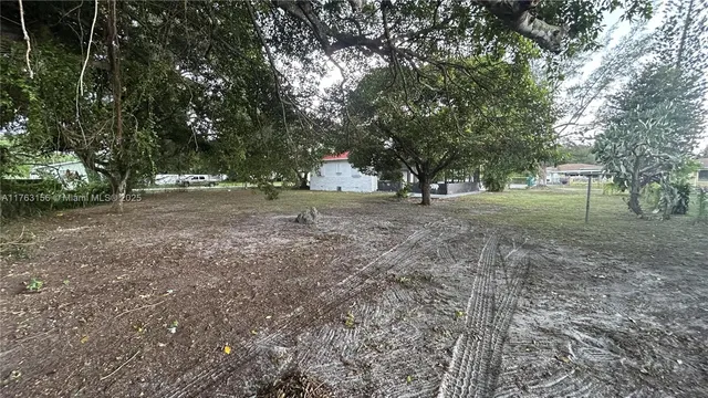 a view of dirt yard with a trees