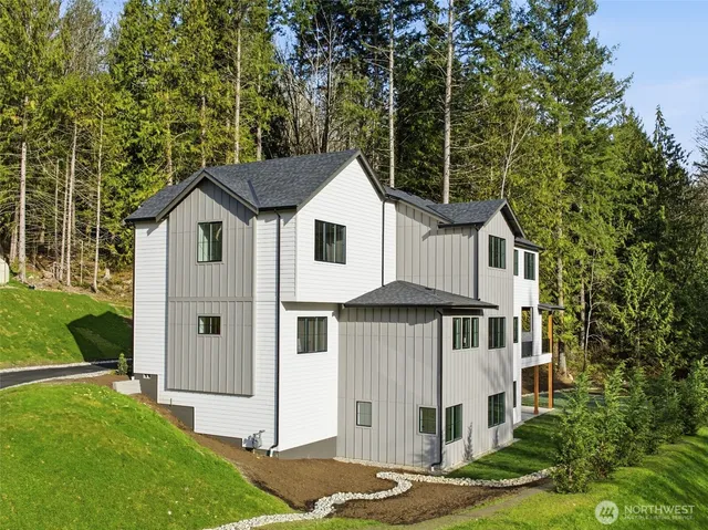 a front view of a residential apartment building with a yard and potted plants