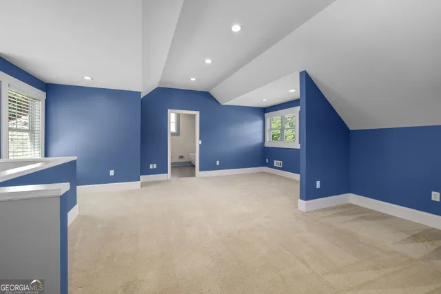 a view of an empty room with window and stairs