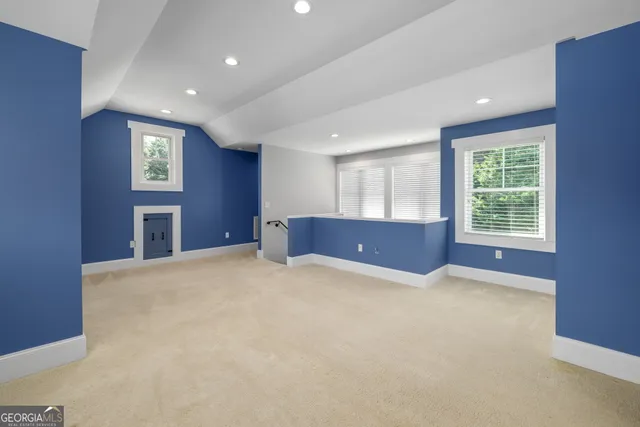 a view of an empty room with a window and fireplace