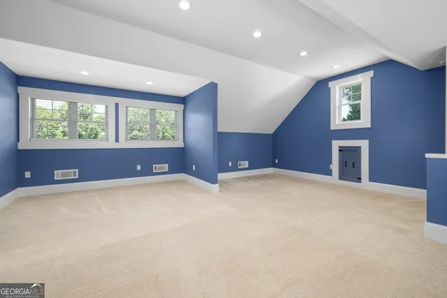 an empty room with windows and ceiling fan