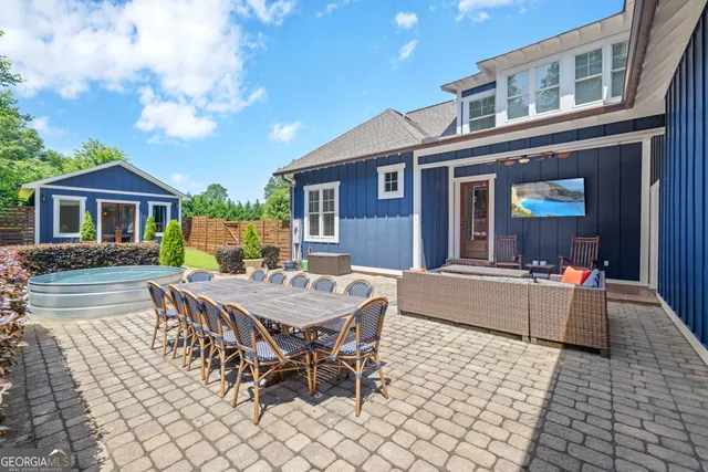 a view of a house with a chairs and table in a patio