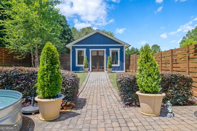 a view of a house with potted plants and a fountain