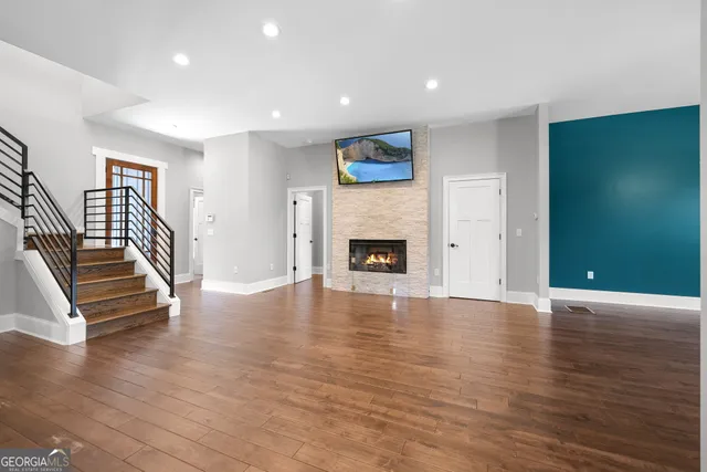 an empty room with wooden floor and a fireplace