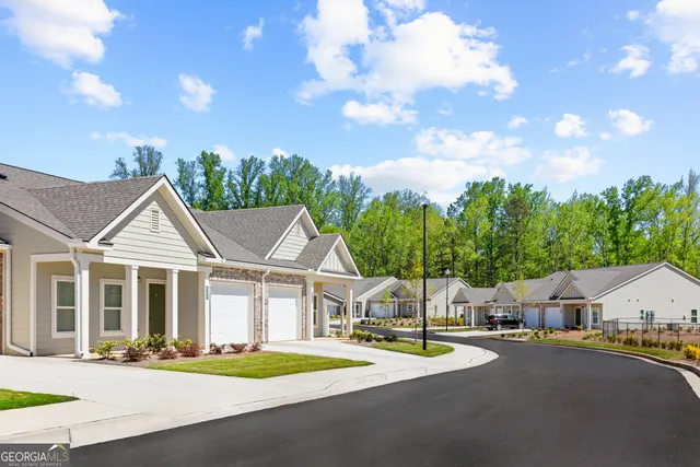 a front view of a house with a garden and trees