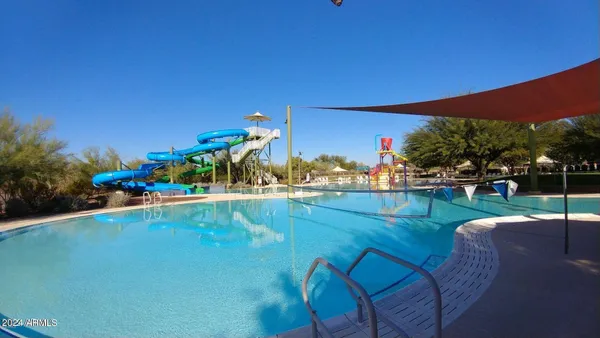 a view of a chairs and table in patio with swimming pool