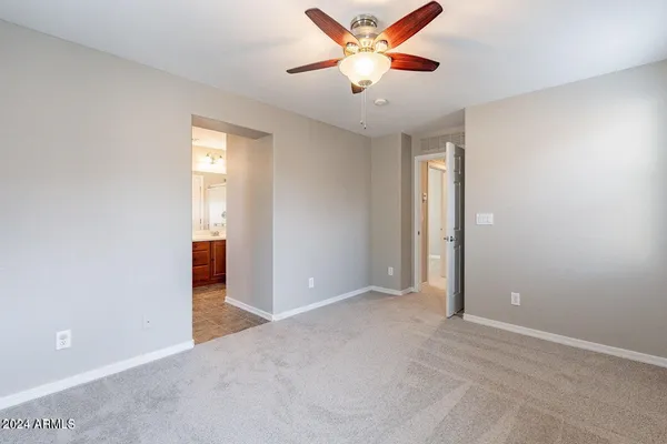 an empty room with closet and a chandelier fan