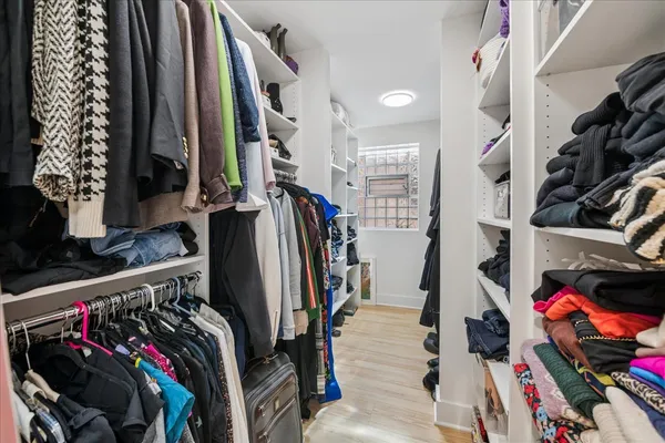 a view of walk in closet with clothes and shoes