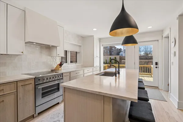 a kitchen with stainless steel appliances granite countertop a sink a stove and a refrigerator