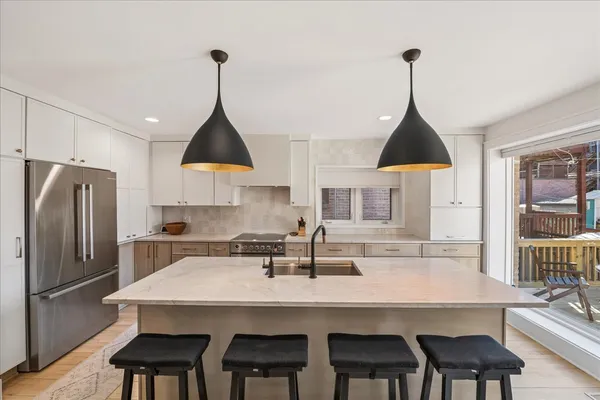 a kitchen with a dining table chairs and cabinets