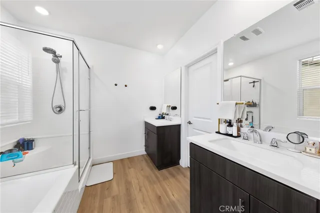 a bathroom with a double vanity sink mirror and shower