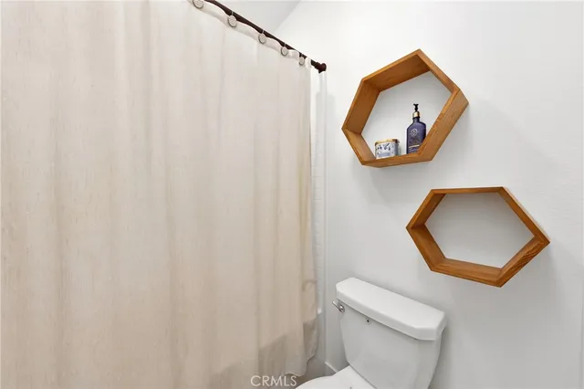 a bathroom with a toilet and a mirror