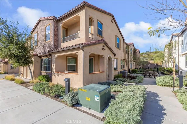 a front view of a multi story residential apartment building with yard and bench