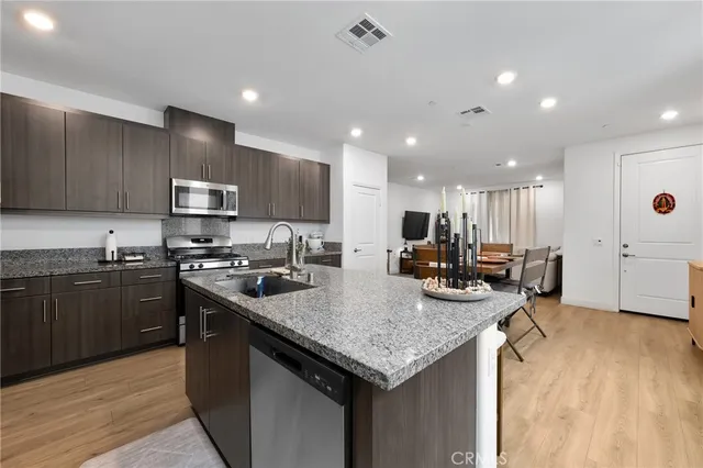a kitchen with stainless steel appliances granite countertop a sink stove and refrigerator