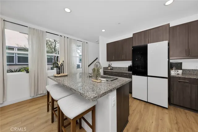 a kitchen with stainless steel appliances granite countertop a refrigerator a stove a sink and a microwave