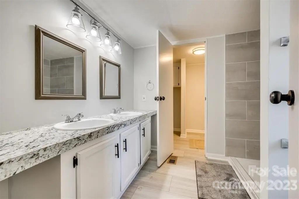 320 North Market Street Lancaster, SC 29720 - Photo 7 of 25 a bathroom with a granite countertop sink a mirror and a shower