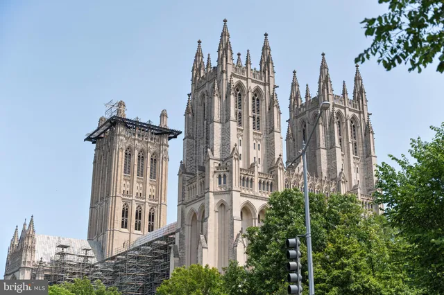 a view of a residential apartment building with a yard and potted plants