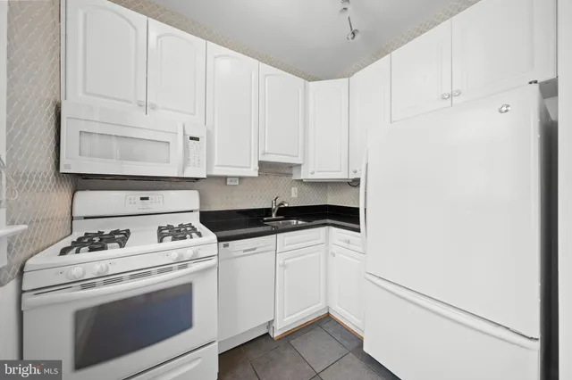 a kitchen with white cabinets and white appliances